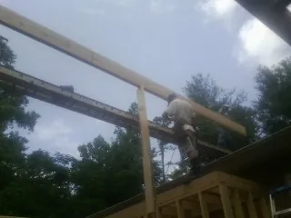 Carpenter setting a ridge beam over a new addition frame — Ice Dam Removal by Roofing Brothers in Sisters