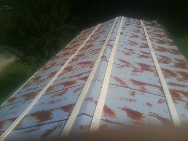 Rusted metal roof panels with new wood purlins before replacement — Storm Damage Roof Repair in Sisters by Roofing Brothers