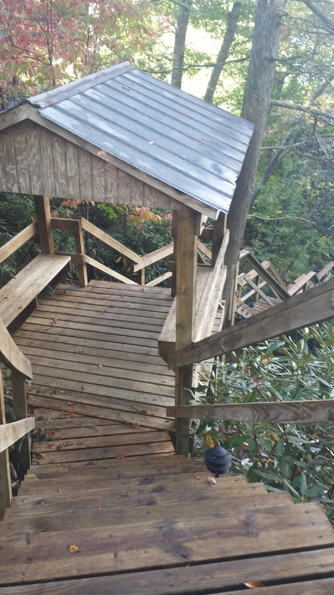 Metal roofed shelter over wooden steps on a wooded walkway — Skylight Repair & Installation work by our crew in Sisters