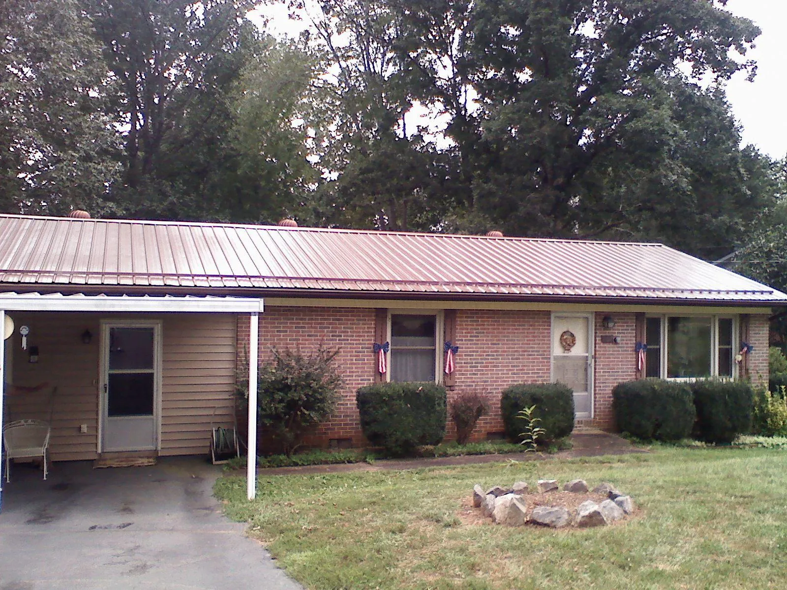 Bronze metal roof and carport on a brick ranch home — Roof Repair work by our crew in Sisters
